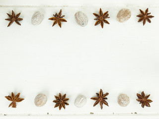 Obraz na płótnie Canvas rows of star anise and nutmeg on a rustic white table top