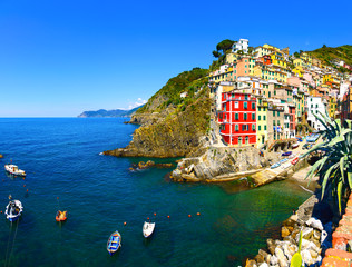 Riomaggiore village, rocks, boats and sea at sunset. Cinque Terr