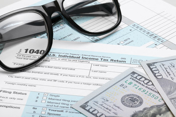 USA Tax Form 1040 with dollars and glasses