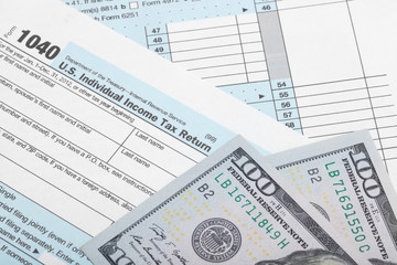 Fototapeta na wymiar USA Tax Form 1040 with two 100 dollars banknotes