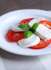 Caprese salad with mozarella cheese, tomatoes and basil