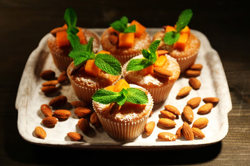 Tasty pumpkin muffins on wooden table