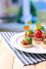Tasty canapes with salami,tomato, pepper  and basil leaves,