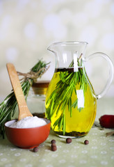 Essential Oil with rosemary in glass jug, on light background