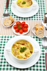 Tasty soup in saucepans on tablecloth, close up