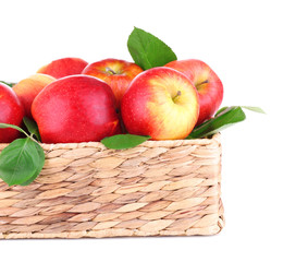 Ripe sweet apples with leaves in wicker crate, isolated on