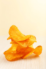 Heap of homemade potato chips on light background