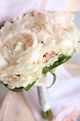 Beautiful wedding bouquet on   wooden chair on light background