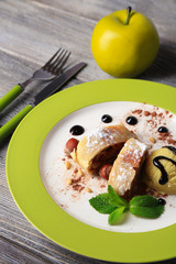 Tasty homemade apple strudel with nuts, mint leaves and