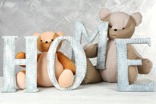 Decorative letters forming word HOME with teddy bear