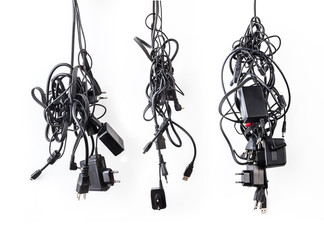 Cluster of messy chaotic power cables and adapters isolated on w