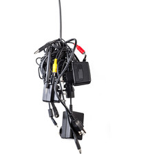 Cluster of messy chaotic power cables and adapters isolated on w