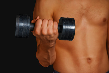 Strong man is lifting dumbbell
