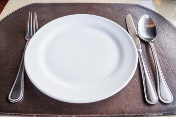 White plate with spoon knife and fork