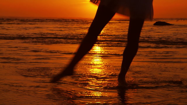 SIlhouette of girl dancing on Beach at sunset