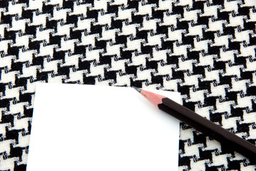 White note pad and pencil on  houndstooth pattern cotton.