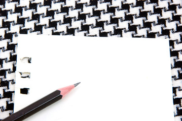 White note pad and pencil on houndstooth pattern cotton.