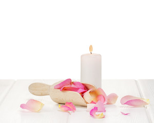 Rose petals on white wooden plates.