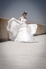 Fototapeta na wymiar Young attractive bride walking with flowy white skirt