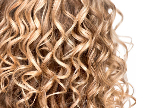 Wavy curly blonde hair closeup. Texture of permed hair