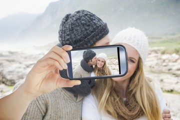 Composite image of hand holding smartphone showing