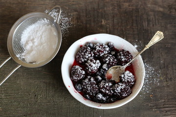 Черника, ежевика в блюдце с ложкой