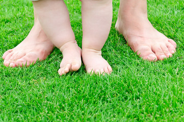 small baby feet on green grass Learn to walk