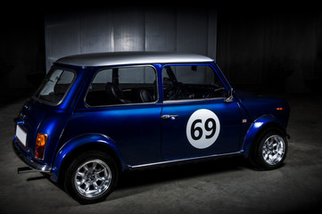 Iconic blue Mini Cooper in a parking area - obrazy, fototapety, plakaty
