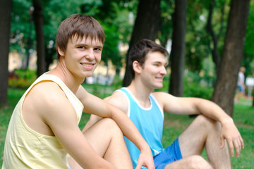 Fototapeta premium Two young man resting after exercising at the park