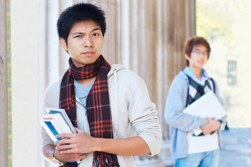 Suspicious asian student outdoors