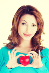 Attractive smiling woman showing red heart