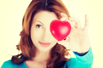 Attractive smiling woman showing red heart