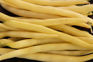 Yellow wax beans on brown background