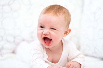 Smiling Baby Girl are Lying in the Bed