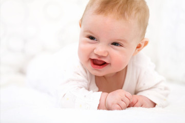 Smiling Baby Girl are Lying in the Bed