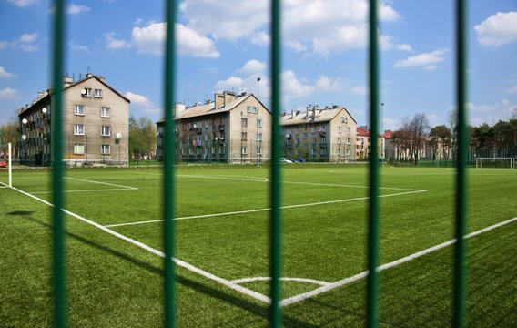 Sport, Soccer field behind the fence, in blocks of flats
