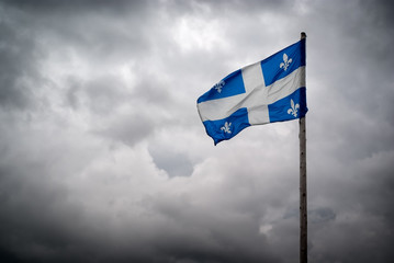 Quebec Flags Waves Before Stormy, Cloudy Skies