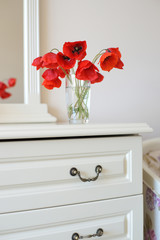 Букет красных маков на комоде
