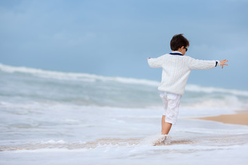 Fototapeta na wymiar Six years old boy playing on atlantic beach