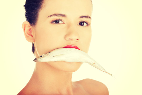 Beautiful woman with fish in her mouth