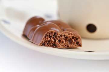 Porous black chocolate on a saucer close-up