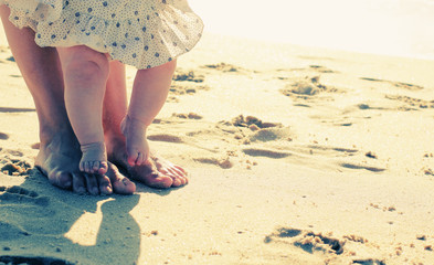 mother and baby feet at the beach sand