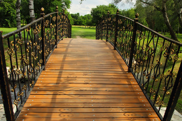 Wooden bridge with wrought-iron details.