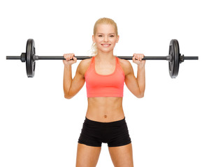 smiling sporty woman exercising with barbell