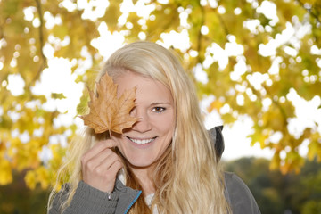 junge Frau mit Herbstblatt