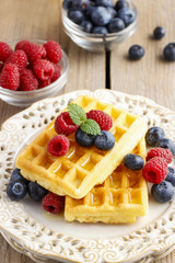 Waffles with syrup, raspberries and blueberries