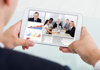 Businessman Video Conferencing With Team On Digital Tablet
