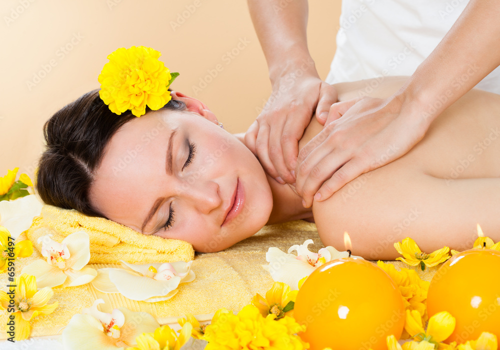 Wall mural smiling woman receiving shoulder massaging in spa