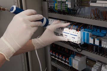 Technician Analyzing Fusebox With Flashlight
