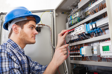 Technician Examining Fusebox With Multimeter Probe